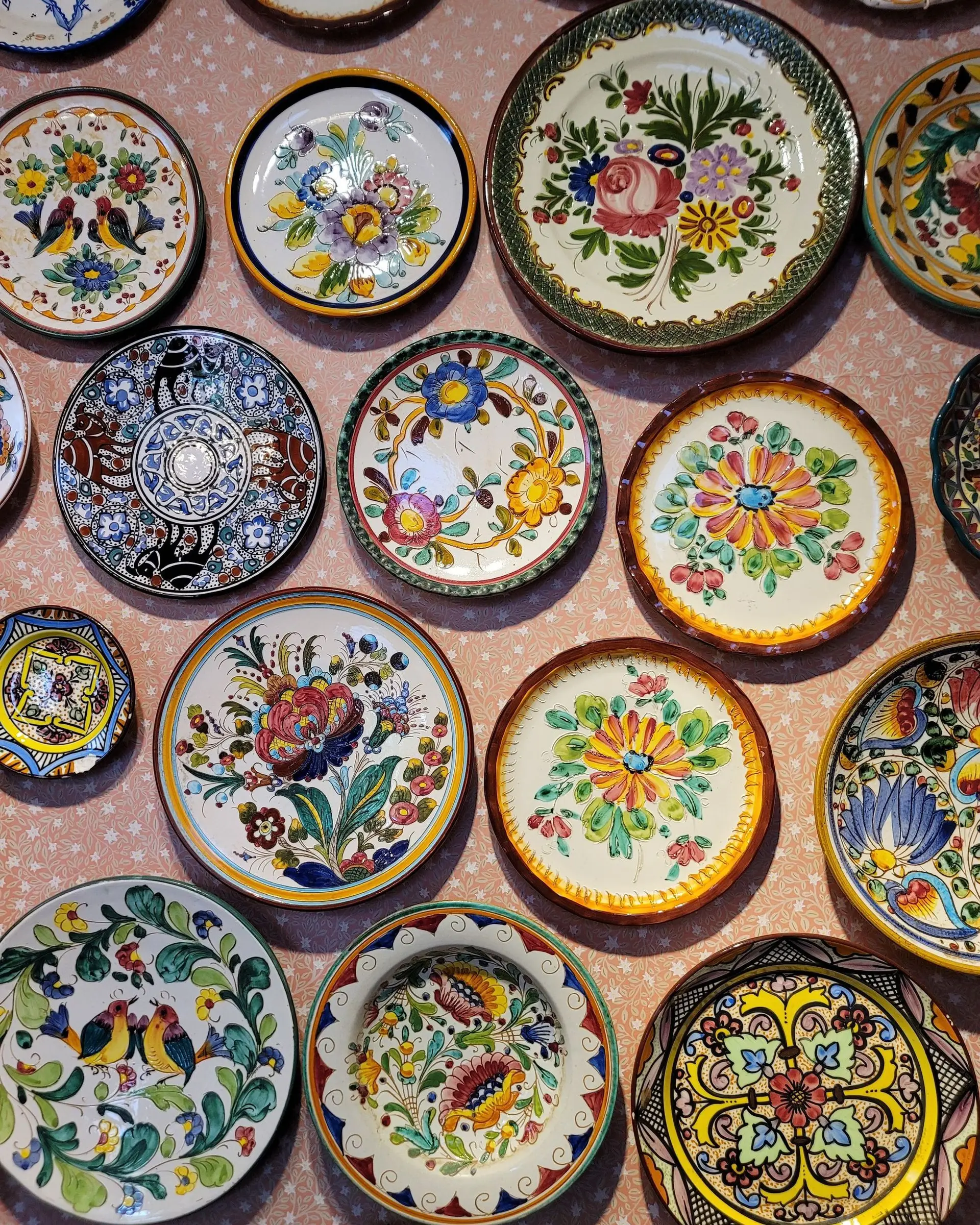 Pared cubierta de platos de cerámica pintados a mano